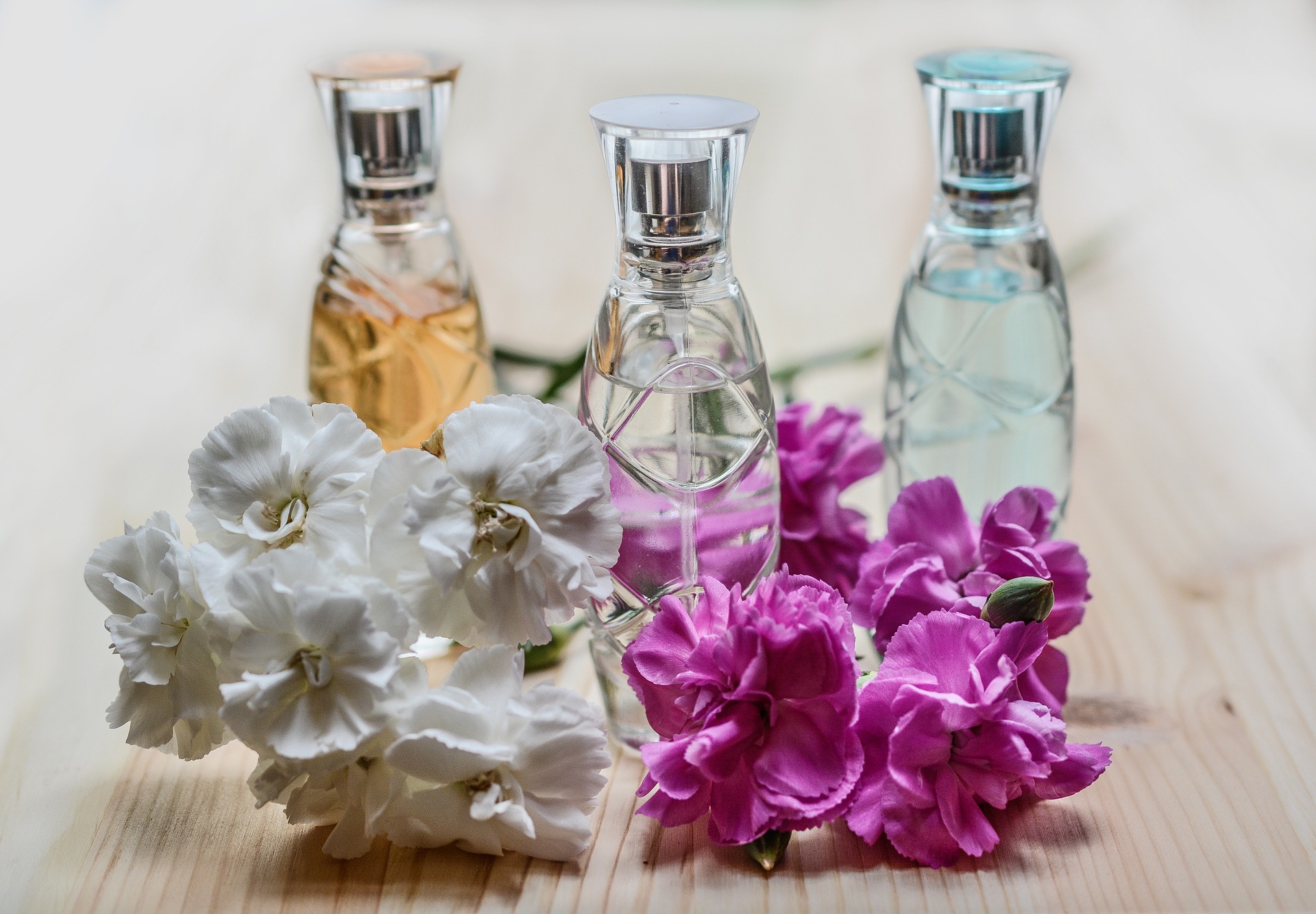 3 perfume bottles and flowers.