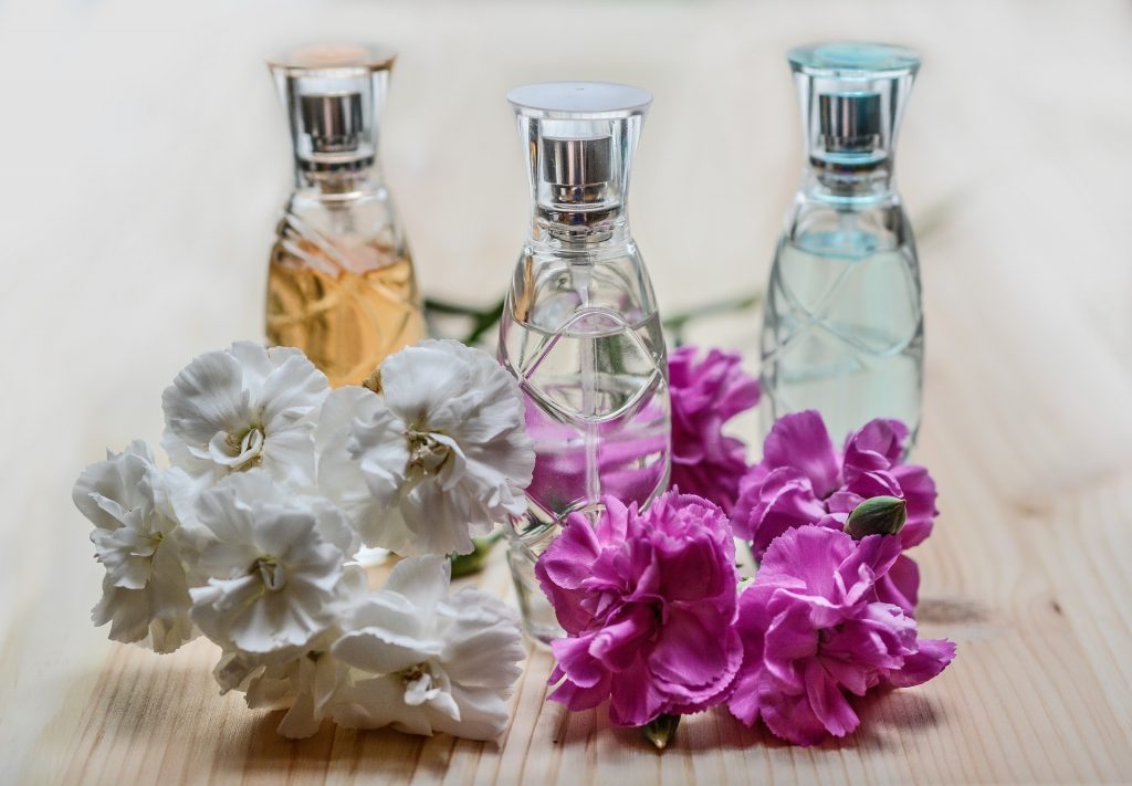 3 perfume bottles and flowers.