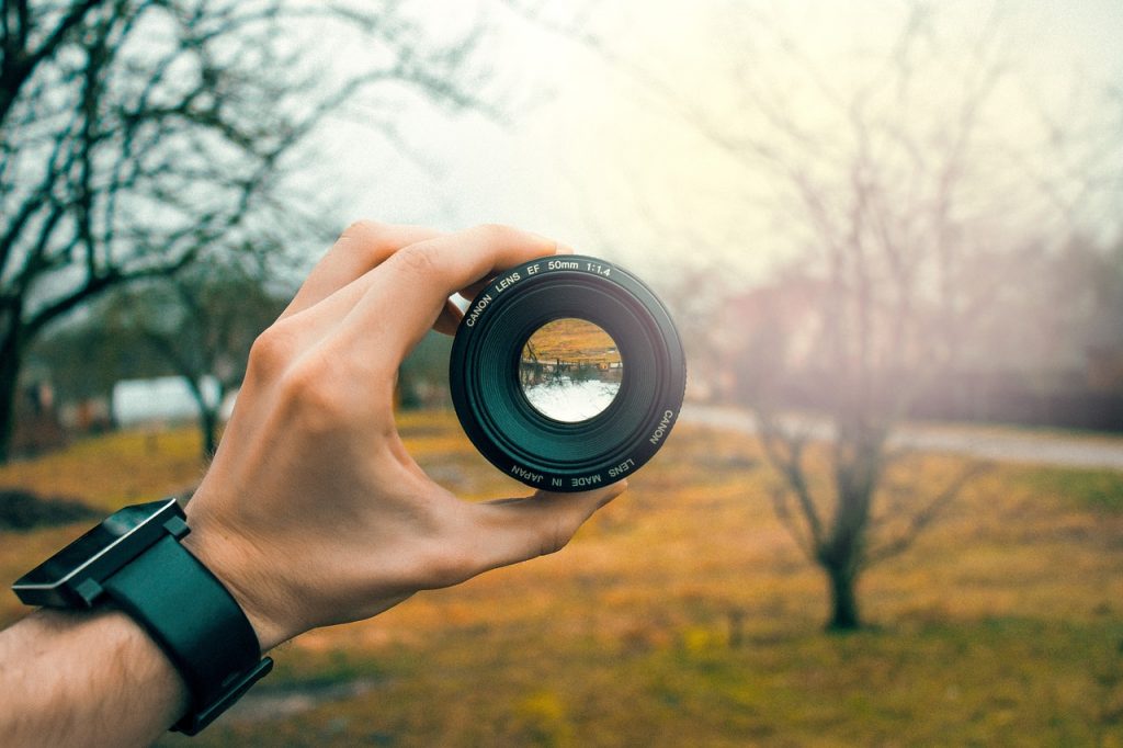 hand holds camera lense