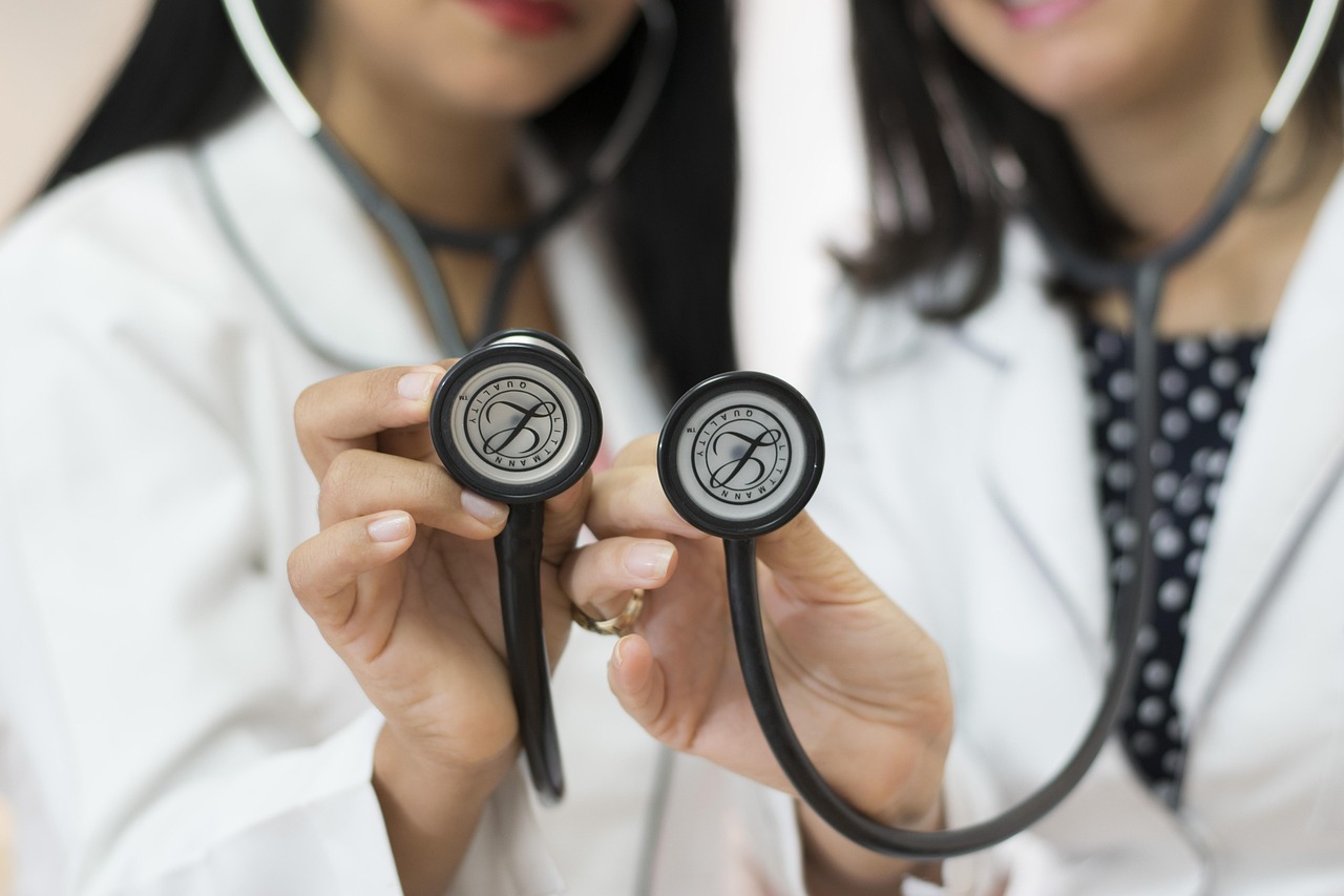 two female doctors holding up stethoscopes